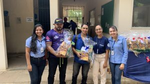 Um grupo de pessoas posando para foto com brindes natalinos em mãos