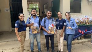 Um grupo de pessoas posando para foto com brindes natalinos em mãos